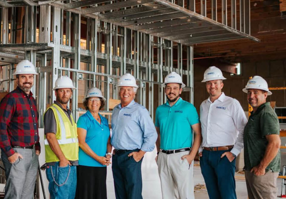 Photo of MEC team Members standing in front of a construction project